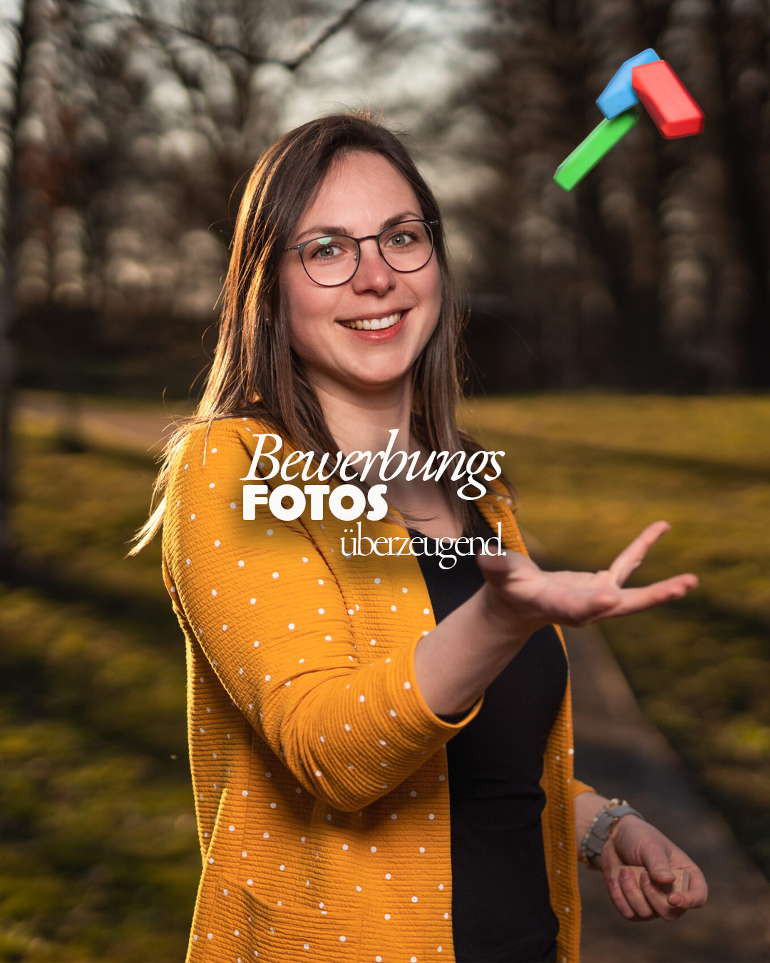Bewerbungsfoto von einer jungen Frau mit Brille, die bunte Spielklötzer in der Hand hält und sie wirft. Fotograf: © Roman Koryzna, Bewerbungsfoto, Studio Koryzna, Fotostudio, Radibor, Bautzen